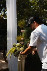 מעצב SECO שוזר פרחים טריים בכלי דקורטיבי בעיצוב אירוע